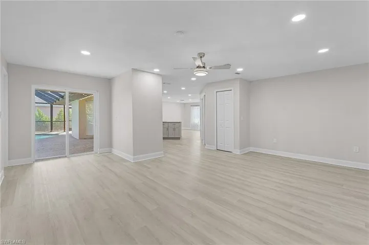 Unfurnished living room featuring ceiling fan and light hardwood / wood-style flooring