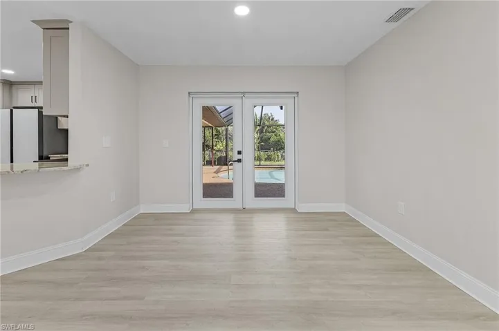 Unfurnished room with french doors and light hardwood / wood-style floors