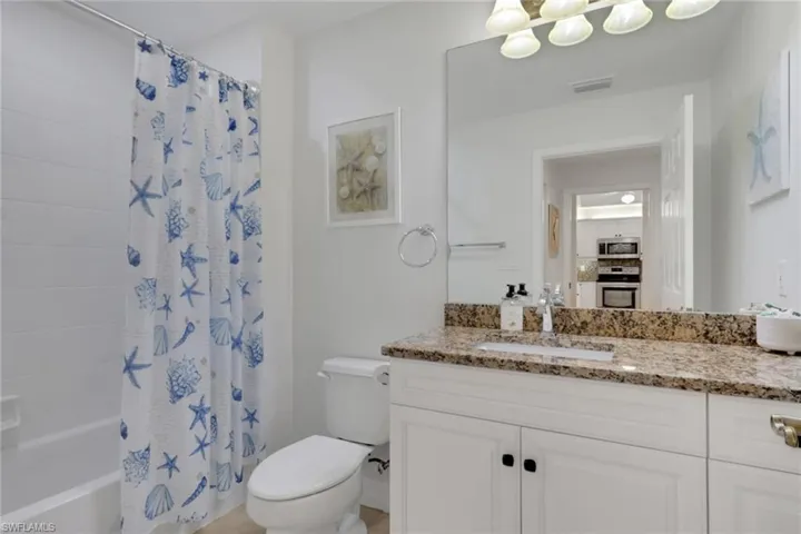 Bathroom featuring vanity and shower / tub combo with curtain