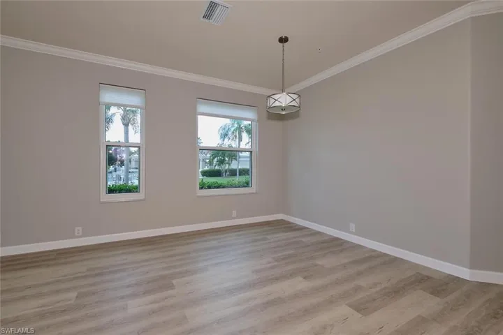 Spare room with ornamental molding and light wood finished floors