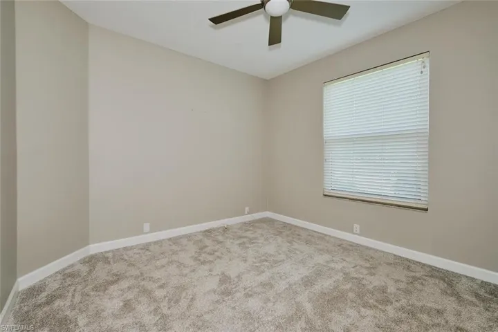 Empty room featuring carpet floors and a ceiling fan