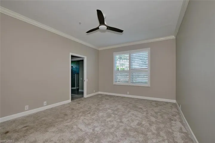 Unfurnished room with crown molding, light carpet, and a ceiling fan