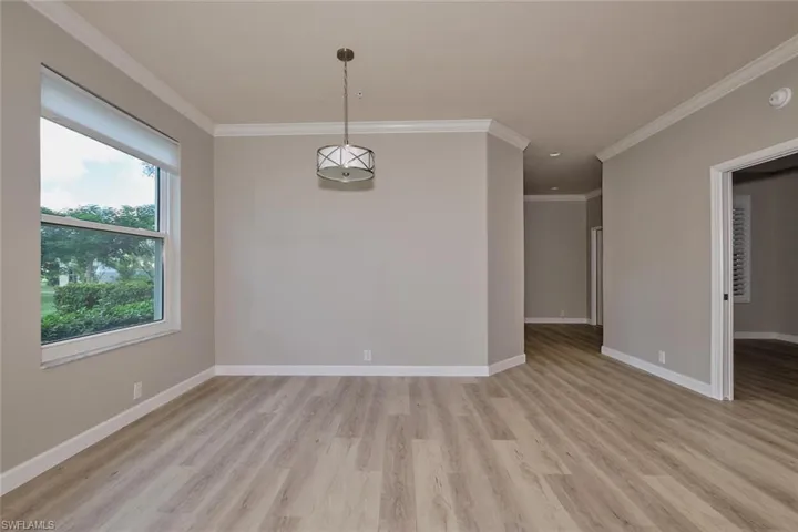 Empty room featuring ornamental molding and light wood-style flooring