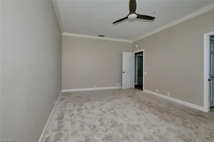 Unfurnished bedroom featuring crown molding, light colored carpet, and ceiling fan