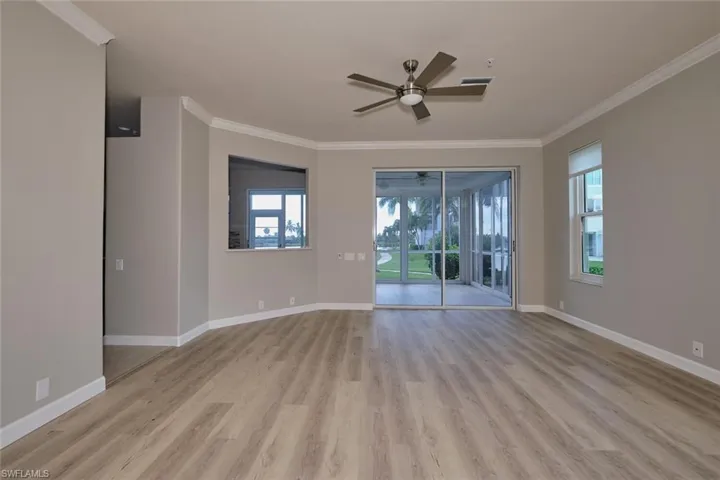 Unfurnished room featuring crown molding, light wood-type flooring, and ceiling fan