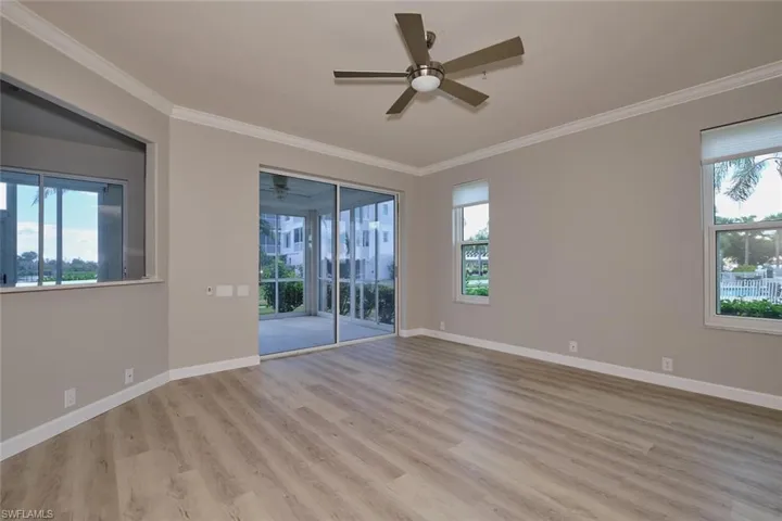 Unfurnished room with ornamental molding, light wood-style floors, and ceiling fan