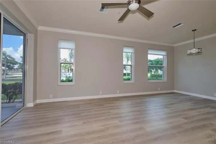 Unfurnished room featuring crown molding, light wood finished floors, and ceiling fan