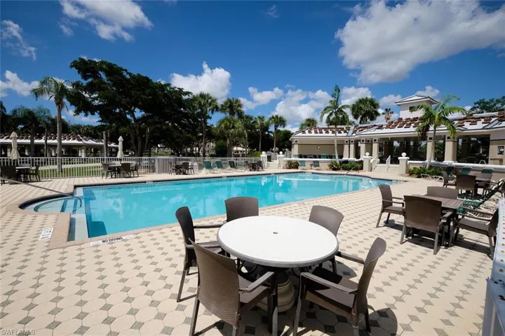 Community pool with a patio and outdoor dining area