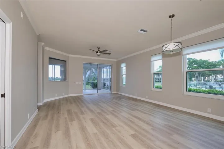 Unfurnished room with crown molding, light wood-type flooring, and ceiling fan