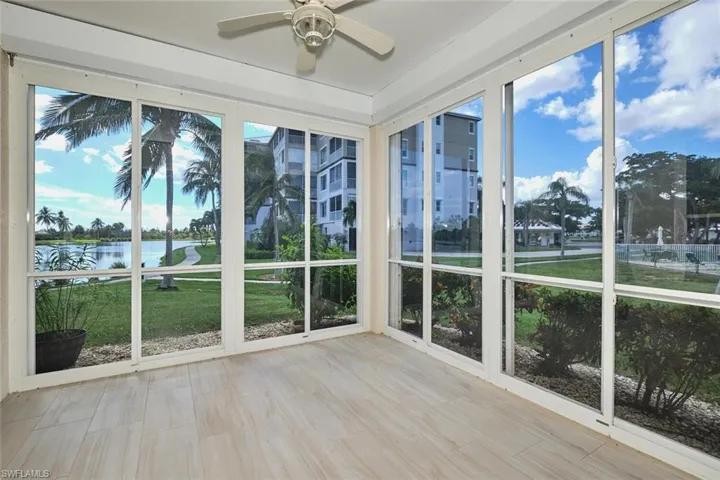 Unfurnished sunroom with a water view and a ceiling fan