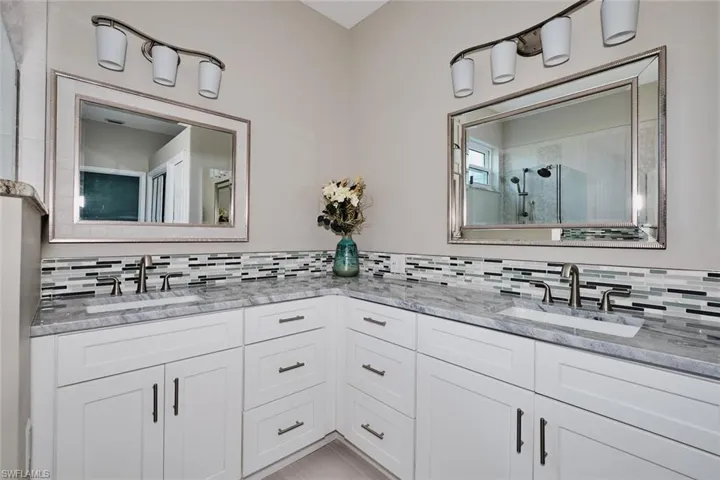 Bathroom featuring double vanity and tiled shower