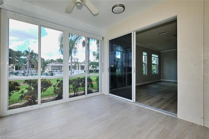 Unfurnished sunroom with a ceiling fan, crown molding, and wood finished floors