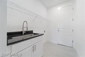Laundry room with light wood-type flooring and cabinet space