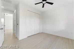 Unfurnished bedroom featuring a closet, light wood-type flooring, and ceiling fan
