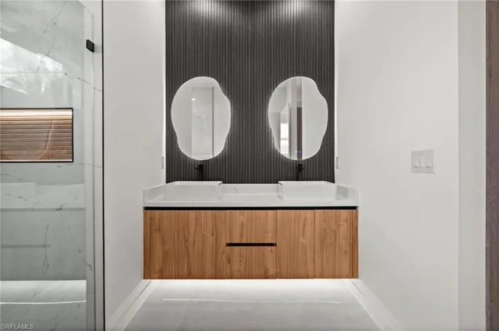 Dual floating vanities featuring wood-finish cabinetry and white vessel sinks