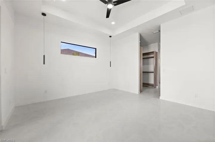 Spacious interior featuring light gray tile flooring, crisp white walls, and a recessed ceiling