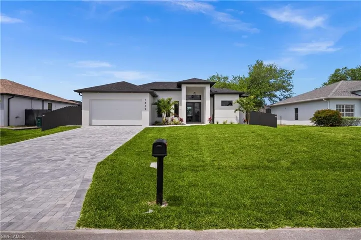 Contemporary single-story residence featuring a dark shingle roof, white exterior, and a two-car garage