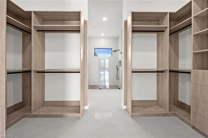 Custom closet system featuring light wood-finish cabinetry, integrated shelving, and hanging rods
