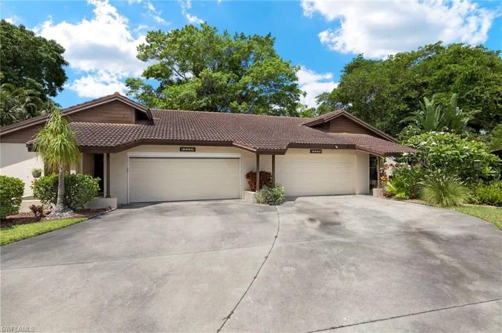 Ranch-style home with driveway, a tile roof, stucco siding, and an attached garage
