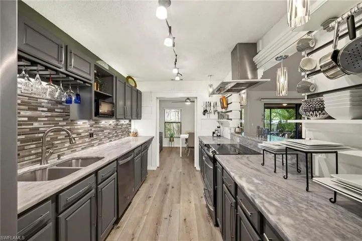 Kitchen with open shelves, electric range, ceiling fan, island exhaust hood, and backsplash