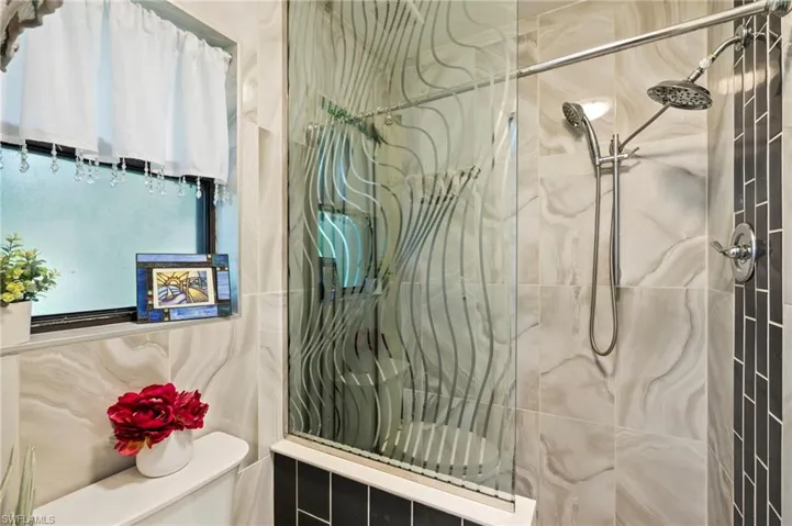 Bathroom featuring a tile shower and toilet