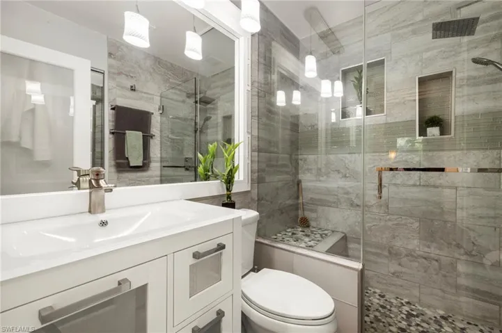 Full guest bathroom featuring beautiful vanity and a shower stall