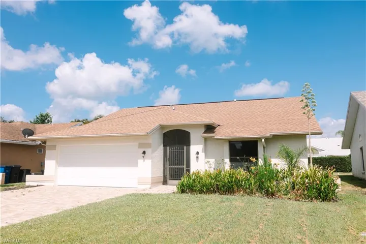 Ranch-style home with a front lawn and a garage