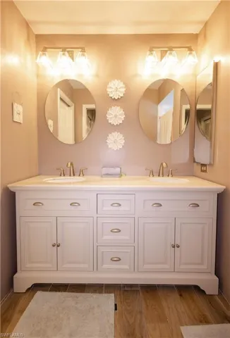 Bathroom featuring dual bowl vanity and hardwood / wood-style floors