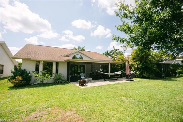 Rear view of house featuring a patio area and a lawn