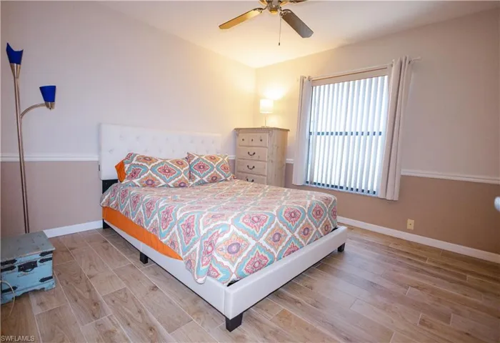 Bedroom with ceiling fan and hardwood / wood-style floors
