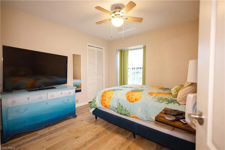 Bedroom with ceiling fan, a closet, and light hardwood / wood-style floors