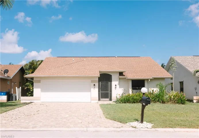 Ranch-style house featuring a front yard and a garage