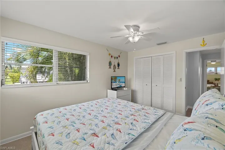 Bedroom with ceiling fan, carpet floors, a closet, and multiple windows