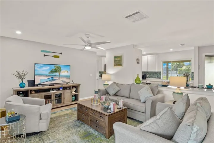 Living room with light hardwood / wood-style floors and ceiling fan