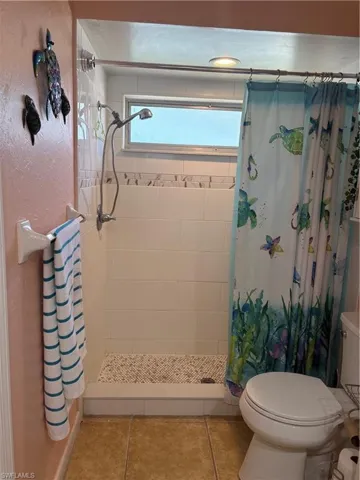 Full bath featuring a stall shower and tile patterned flooring