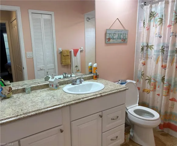 Bathroom with a closet, vanity, and ensuite bath