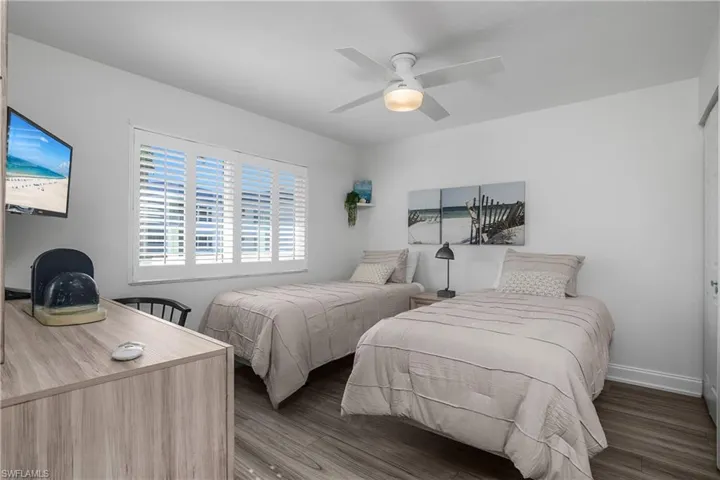 Bedroom with light wood finished floors, ceiling fan, and a closet