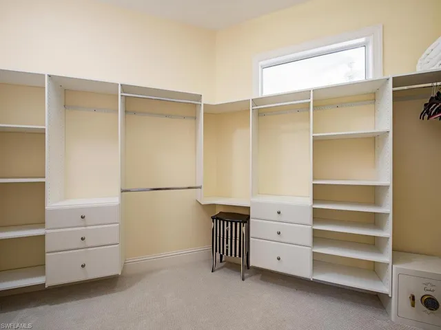 Walk in closet featuring light carpet