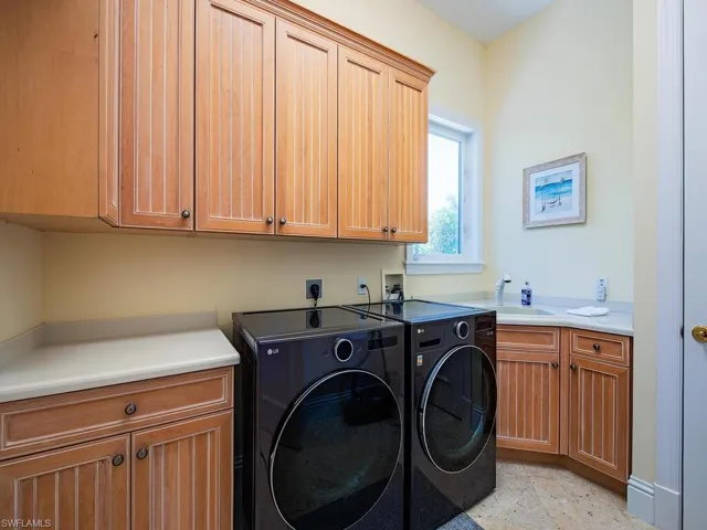 Washroom featuring cabinet space and washing machine and dryer