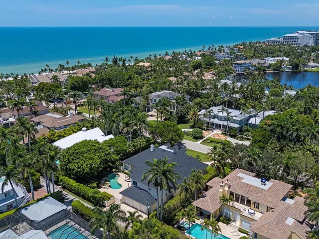 Aerial perspective of suburban area with a pool and a nearby body of water
