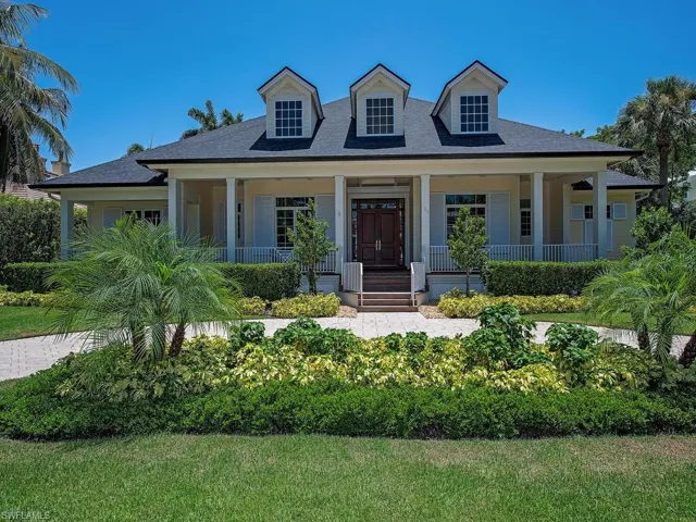 View of front of property with covered porch and a shingled roof