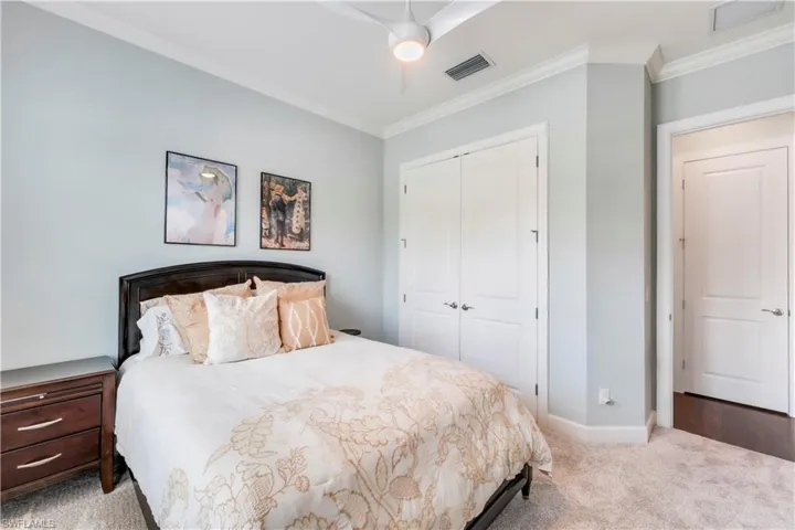 Bedroom with a closet, crown molding, carpet flooring, baseboards, and ceiling fan