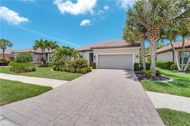 Mediterranean / spanish-style house featuring a front yard, a garage, stucco siding, a tile roof, and decorative driveway
