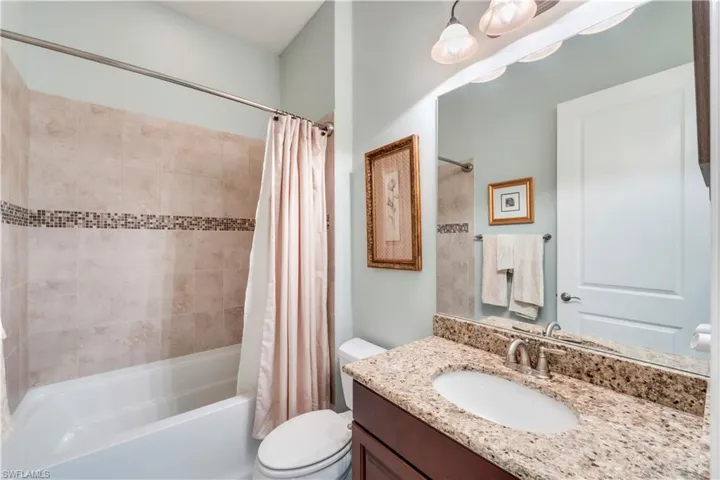 Full bathroom featuring shower / tub combo, toilet, and vanity