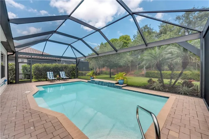 Outdoor pool featuring a patio area and glass enclosure