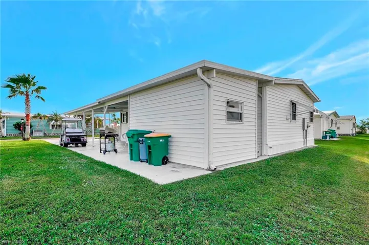 View of property exterior with a yard and a patio