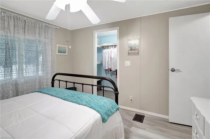 Bedroom with a closet, light hardwood / wood-style floors, a spacious closet, and ceiling fan