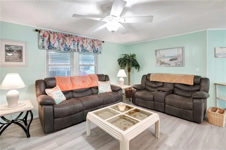 Living room featuring ceiling fan, crown molding, and light hardwood / wood-style flooring