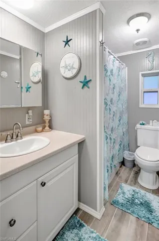 Bathroom featuring vanity, wood-type flooring, a textured ceiling, and toilet