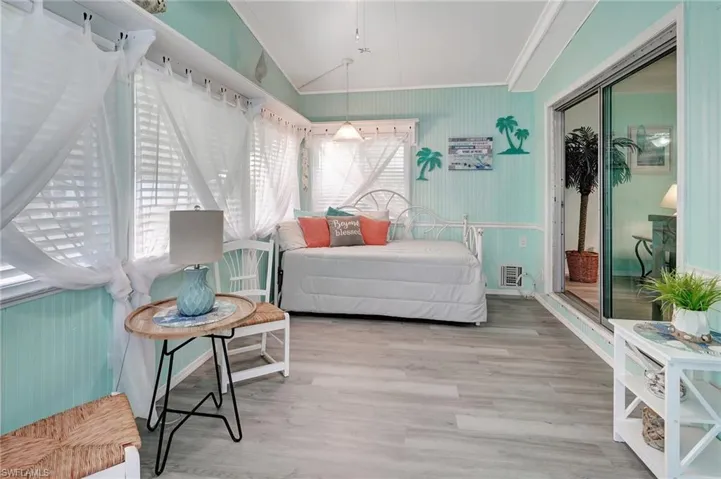Bedroom with a closet, hardwood / wood-style floors, crown molding, and lofted ceiling